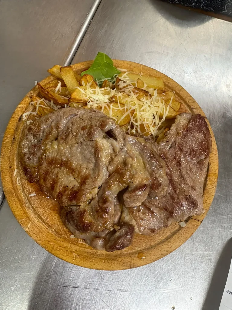 Ceafă cu cartofi pai și cașcaval, preparat la restaurantul Tip Top